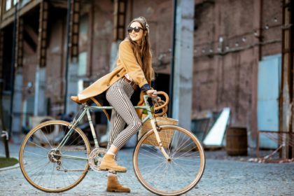 Stylish woman with retro bicycle outdoors