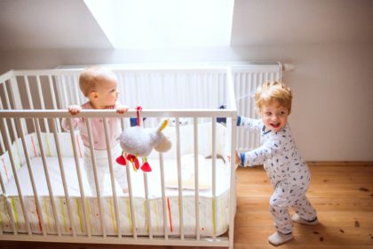 Two toddler children in bedroom at home.