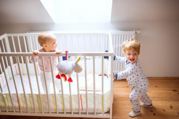 Two toddler children in bedroom at home.
